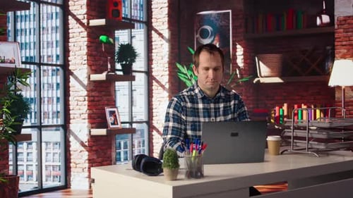 Freelancer in Home Office Sitting at Desk and Typing on Laptop Keyboard