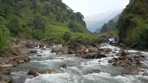 An amazing picturesque mountain landscape with a rushing river in the Himalayan Mountains of Nepal.