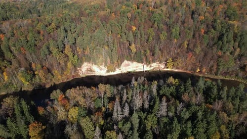 Aerial view of a winding river surrounded by vibrant autumn foliage