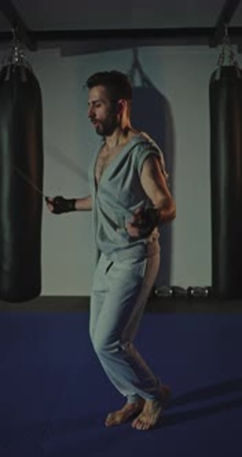 Muscular Man Cardio Workout with Jump Rope in Sport Club