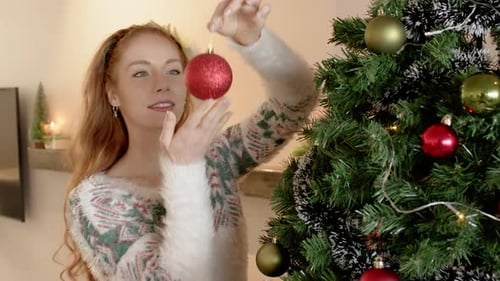 Woman Decorating Christmas Tree with Festive Ornaments