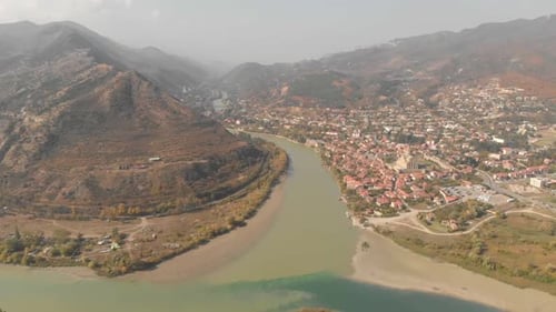 Flying over a fork in the river towards the city of Mtskheta, Georgia, tucked into a mountain valley
