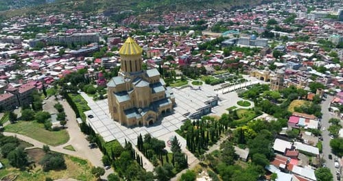 Sameba Cathedral Over Elia Hill Along Mtkvari (Kura) River In Old Tbilisi, Georgia. Aerial Drone Sho
