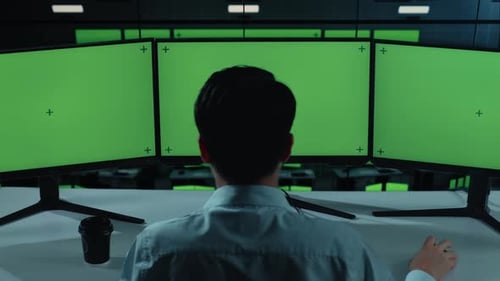 Hombre asiático trabajando con una maqueta de monitor de computadora múltiple en la oficina