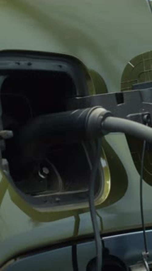 Vertical Video Close Up of EV Vehicle Being Left to Charge in Parking Lot