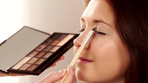Makeup Artist Applying Shadow On Female Eye