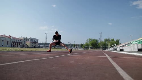 A Man of Athletic Physique Does a Warmup on His Feet