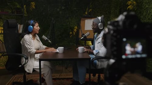 Podcast Cohosts Having Discussion in front of Camera in Recording Studio