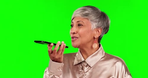 Phone, voice note and senior woman on green screen for conversation, chatting and discussion