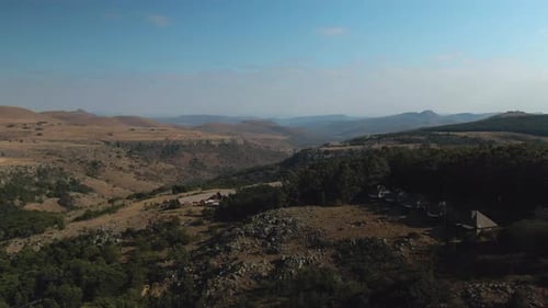 Drohnen-Luftaufnahmen einer Bergschlucht mit Chalets am Rand.