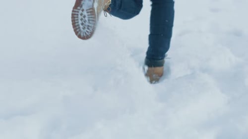 Woman's Boots Walking Through Snow in Urban Setting