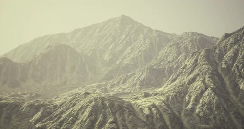 Majestic Mountain Range Under Soft Sunlight in a Serene Landscape