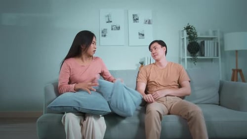 Couple Arguing on Sofa in Apartment Living Room