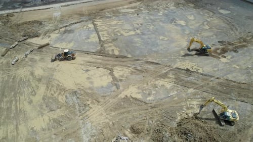 An Aerial view of a Construction equipment, excavators, tractors, bulldozers and working in a constr