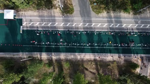 Aerial View of Triathlon Where People Run Then Take Bikes on Special Parking and Start Riding