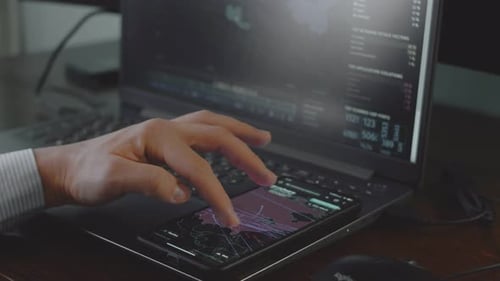 Man Working With Technology on Laptop and Phone