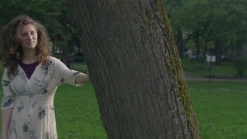 Woman Leaning and Playing near Tree in Green Park
