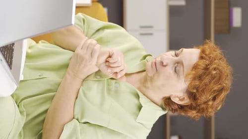 Woman Massaging Wrist While Using Laptop