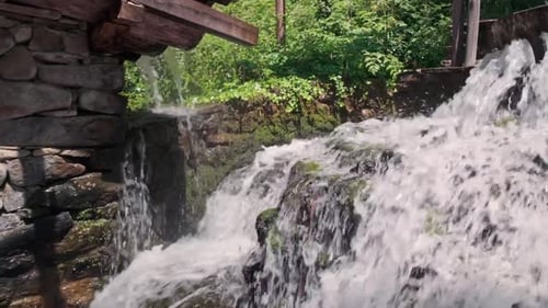 Cool refreshing cascading water splashing over rocks at rustic mill