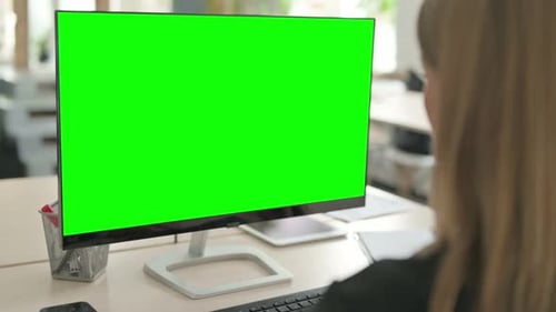 Young Businesswoman Working on Computer with Green Screen