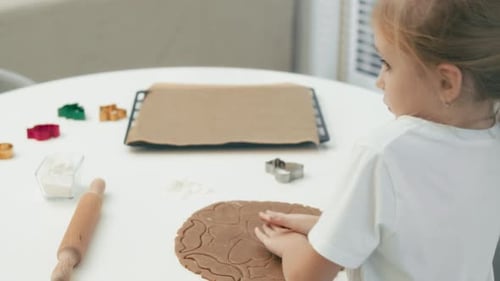 Little Girl Cutting Out Cookies in Kitchen