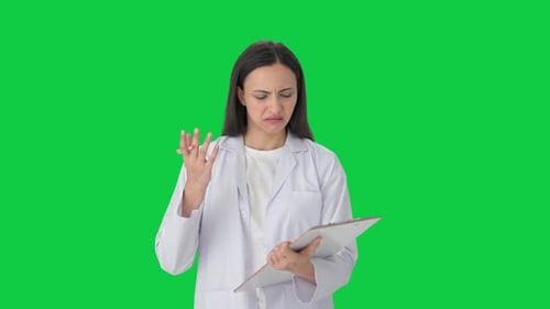 Confused Indian female scientist taking notes Green screen