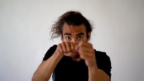 Hispanic Boxer With Goatee and Ponytail Punching Toward Camera in Slow Motion, close up