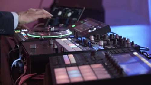 A DJ Works on His Sound Mixing Board at an Event Closeup