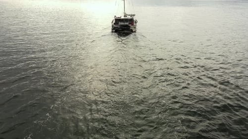 Ein Segelboot schwimmt vor dem Hintergrund eines Sonnenuntergangs auf dem Wasser