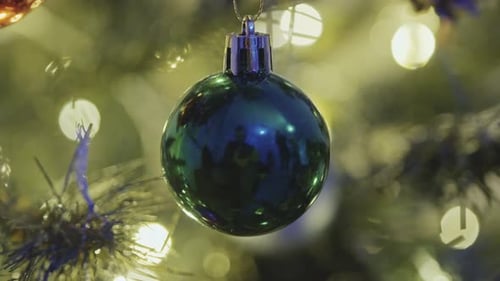 Green Christmas Ornament Hanging on Tree Branch