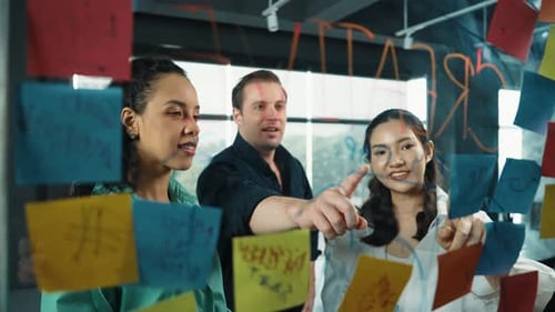 Colleagues Brainstorming Together Using Sticky Notes in Office