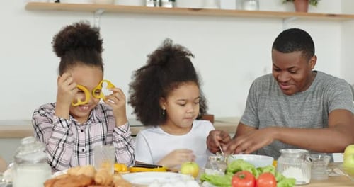 Father and Daughters Preparing Food Together at Home