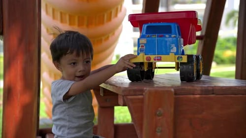 Young Child Plays with Toy Truck Outdoors