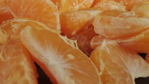Peeled Tangerines on a Black Background Slices of Tangerine or Mandarin Fruit Close Up