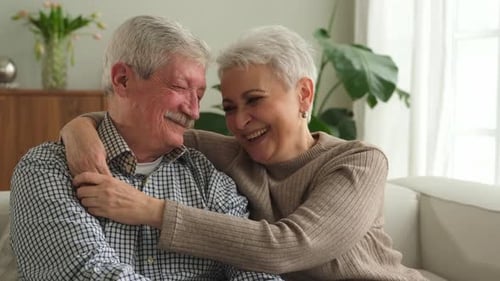 Smiling Senior Couple Embracing Affectionately Indoors