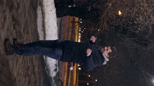 Man Dances with Joyful Energy in Winter City Night