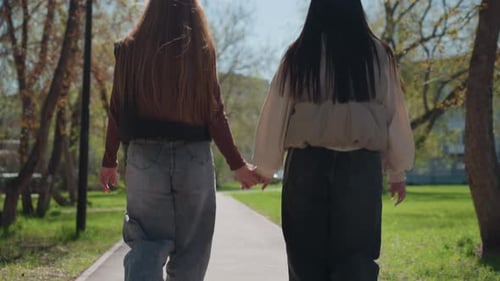 Ladylike Walk Along Sundappled Shaded Pathway Relaxed Women of Caucasian and Asian Descent Enjoying