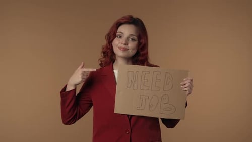 Medium Isolated Video of a Joyful and Relaxed Young Woman Holding a Piece of Cardboard That Says