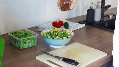 Preparing Healthy Salad with Seeds in Kitchen