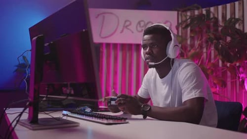 Young Adult Gamer Playing Video Game in Room
