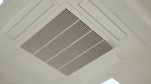 Arc Shot Of Central Air Conditioner Fixed In Ceiling of Business Office