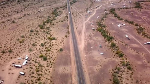 Aerial drone view following vehicles on highway thru desert and dispersed camping area - Quartzite A