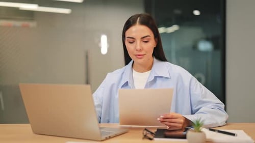 Professional Woman Reviewing Documents in Modern Office