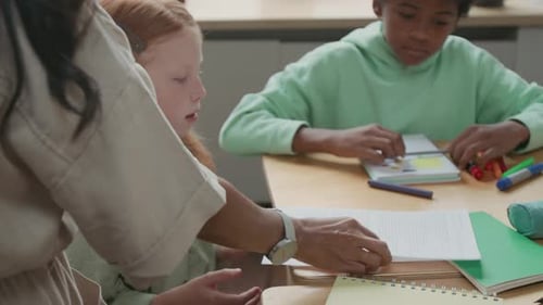 Teacher Giving Assignments to Children in Classroom