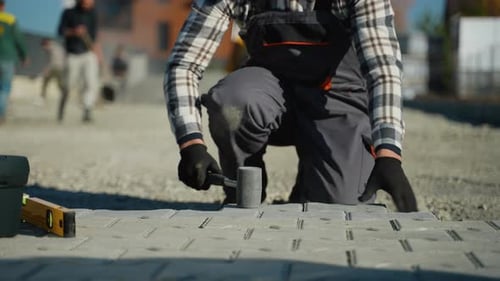 Construction Worker Installing Paving Stones on Site