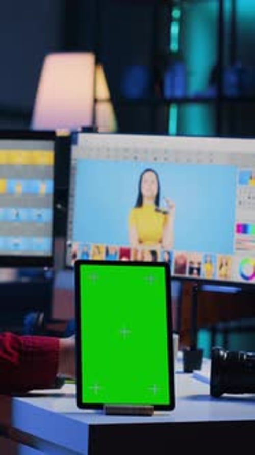 Vertikales Video-Chroma-Key-Tablet auf dem Schreibtisch neben dem Fotoeditor, der in unabhängiger Produktion arbeitet