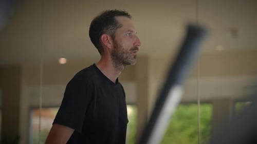 A Focused Male Engaged in a Rigorous Workout Routine in a Modern Gym Environment