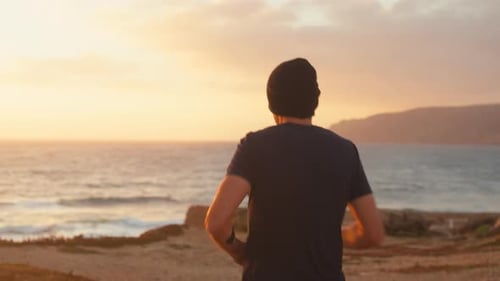 Athletic Man Jogging Running on Ocean Beach at Sunset Background