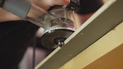 Master Polishes Edge of Plywood Detail with Tool in Workshop