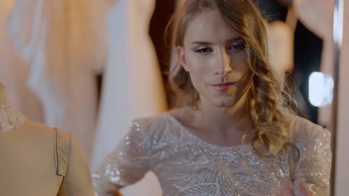 Glamorous Woman Posing in Front of Wedding Gowns